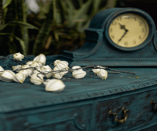 dried flowers next to an old clock